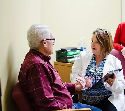 Hearing specialist discussing care options with a patient while holding a tablet