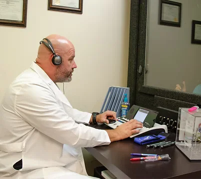 Hearing Instrument Specialist reviewing patient records at Natural Hearing Centers in Hot Springs Village