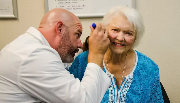 Hearing specialist evaluating a patient's hearing at Natural Hearing Centers in Hot Springs Village, Arkansas