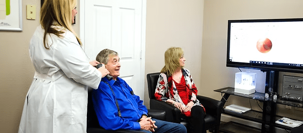 Hearing Instrument Specialist providing a one-on-one consultation to a patient at Natural Hearing Centers in Hot Springs