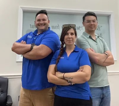 Natural Hearing Centers staff standing together inside the clinic posing for a team photo