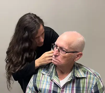 Hearing Instrument Specialist checking a patient's hearing during a clinical appointment at Natural Hearing Centers in Little Rock