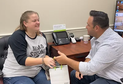 Hearing specialist greeting a patient during a consultation at Natural Hearing Centers office