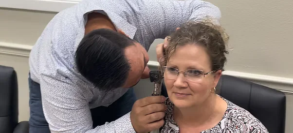Hearing provider examining a patient’s ear during an appointment at Natural Hearing Centers