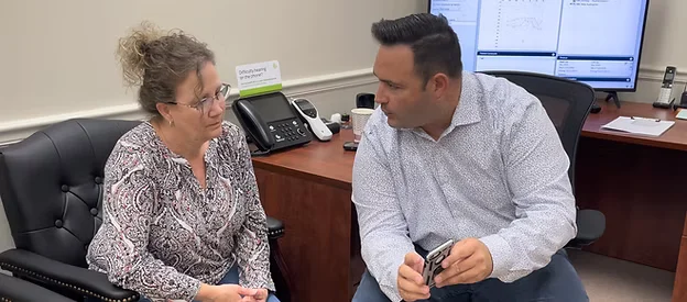 Hearing provider explaining hearing device options to a patient at Natural Hearing Centers